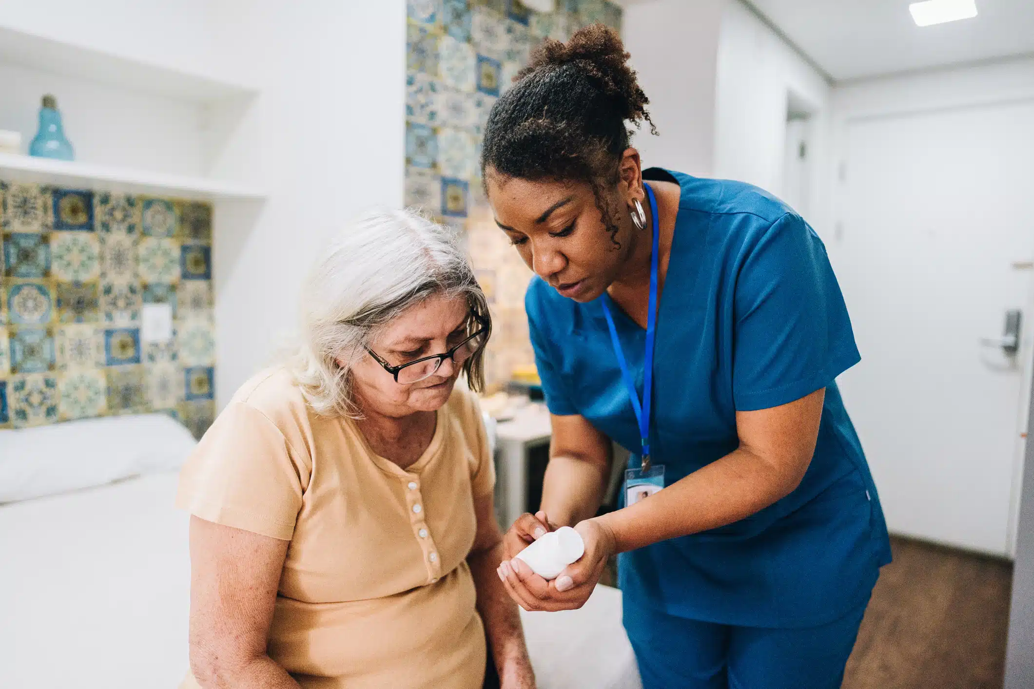 Home caregiver explaining to senior woman how to take her medicine at home Nurse explaining to senior woman how to take her medicine at home