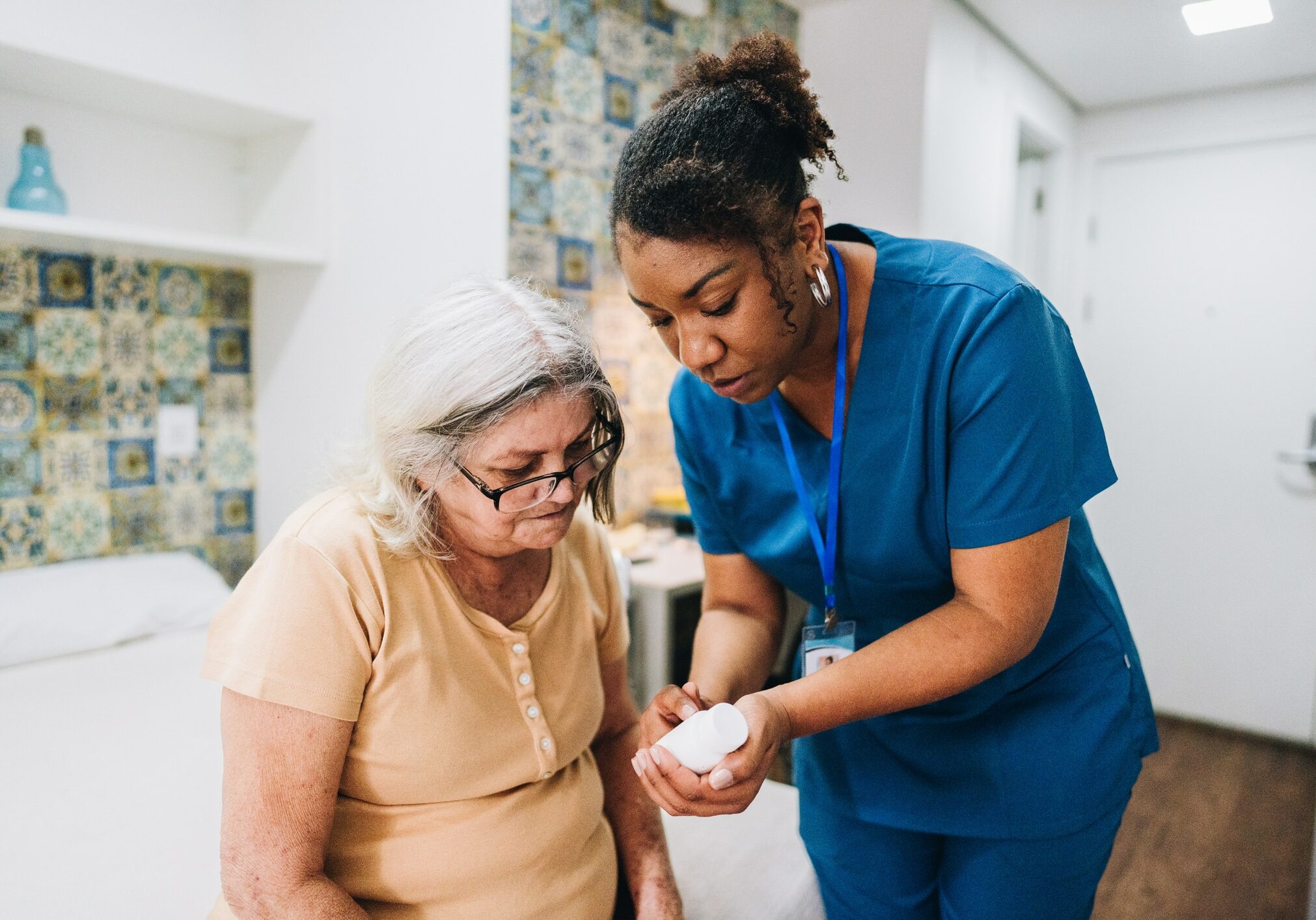 Home caregiver explaining to senior woman how to take her medicine at home Nurse explaining to senior woman how to take her medicine at home