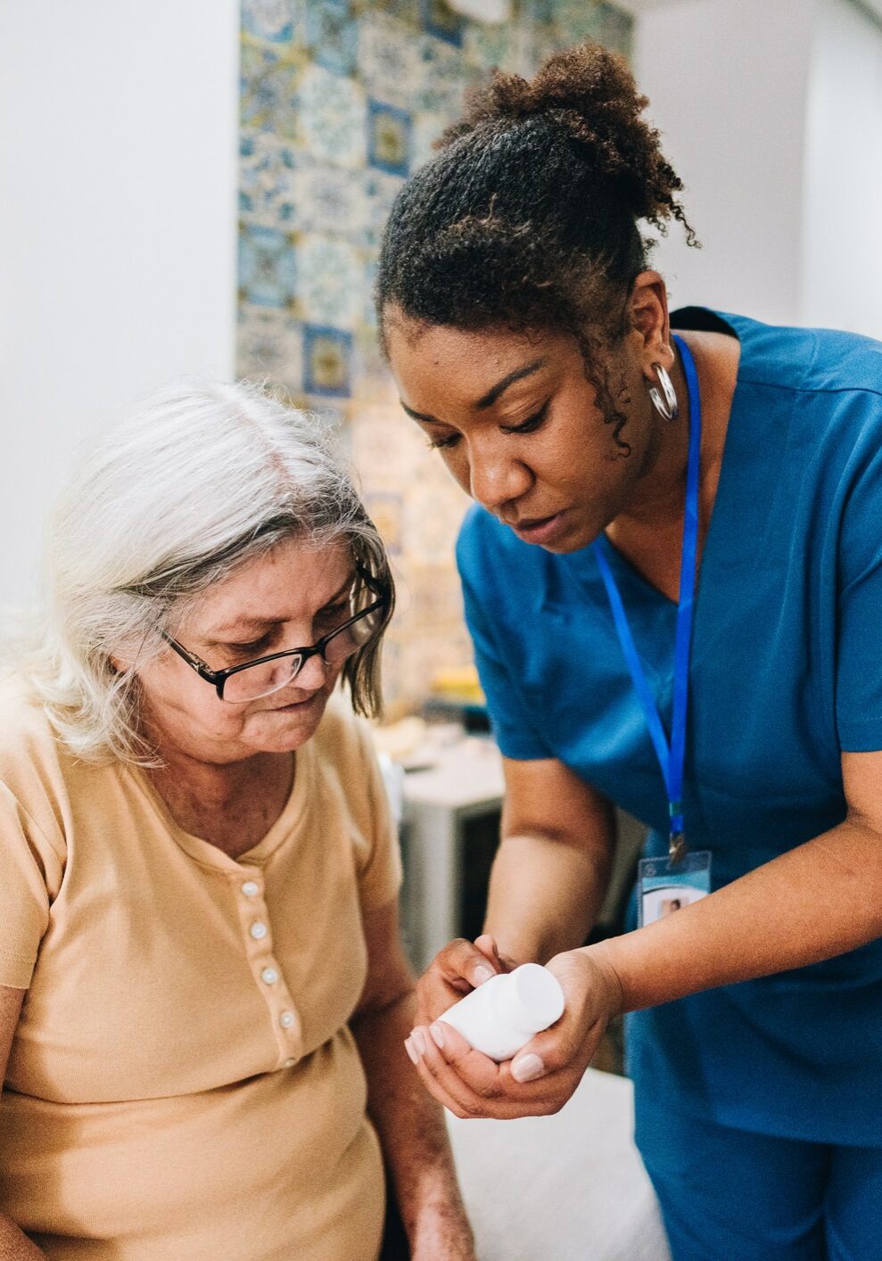 Home caregiver explaining to senior woman how to take her medicine at home Nurse explaining to senior woman how to take her medicine at home